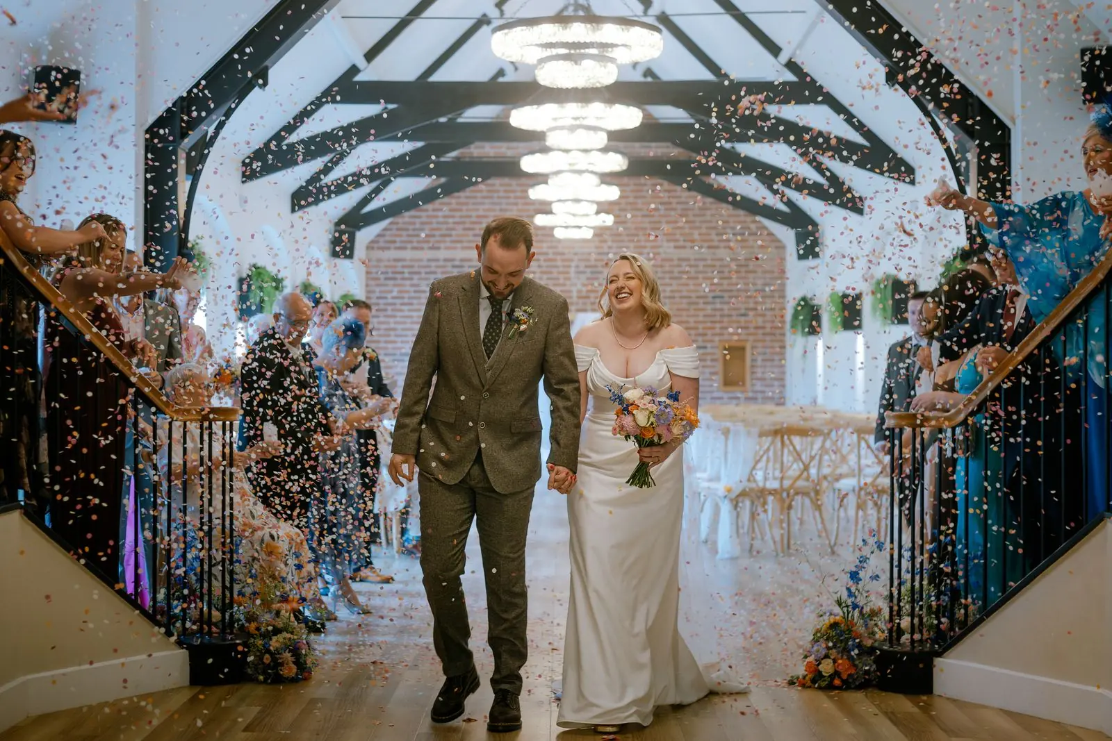 Newlyweds walking through a cloud of confetti