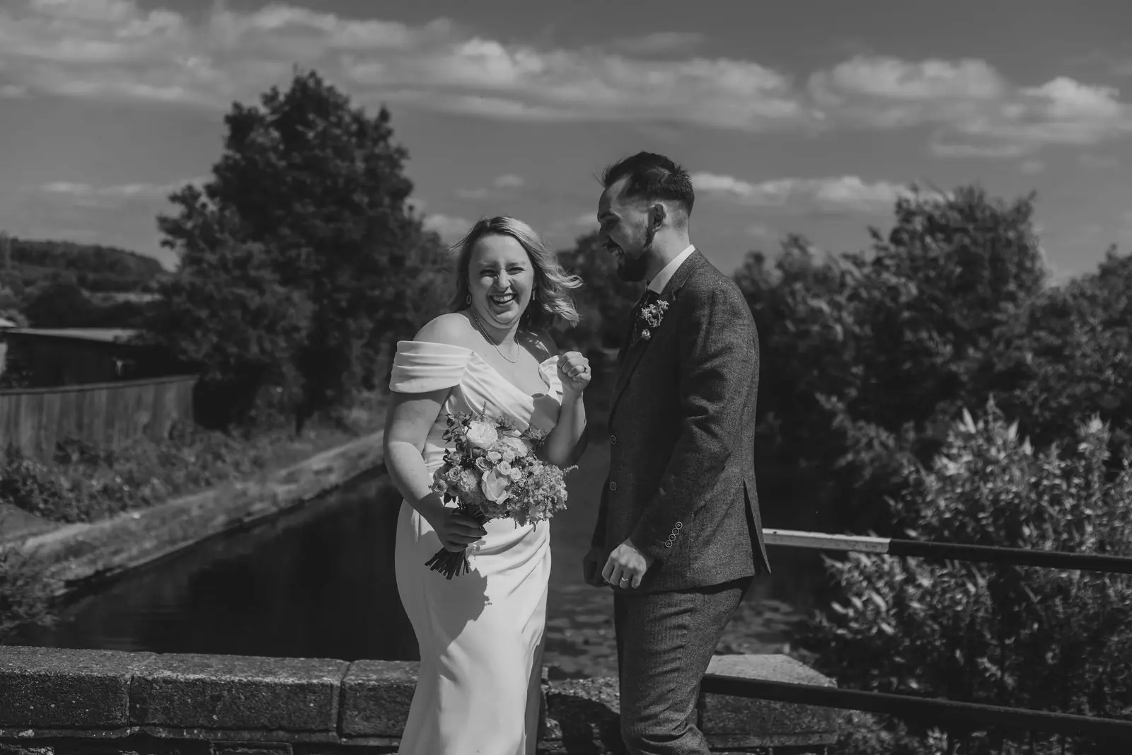 Couple laughing together outdoors in black and white