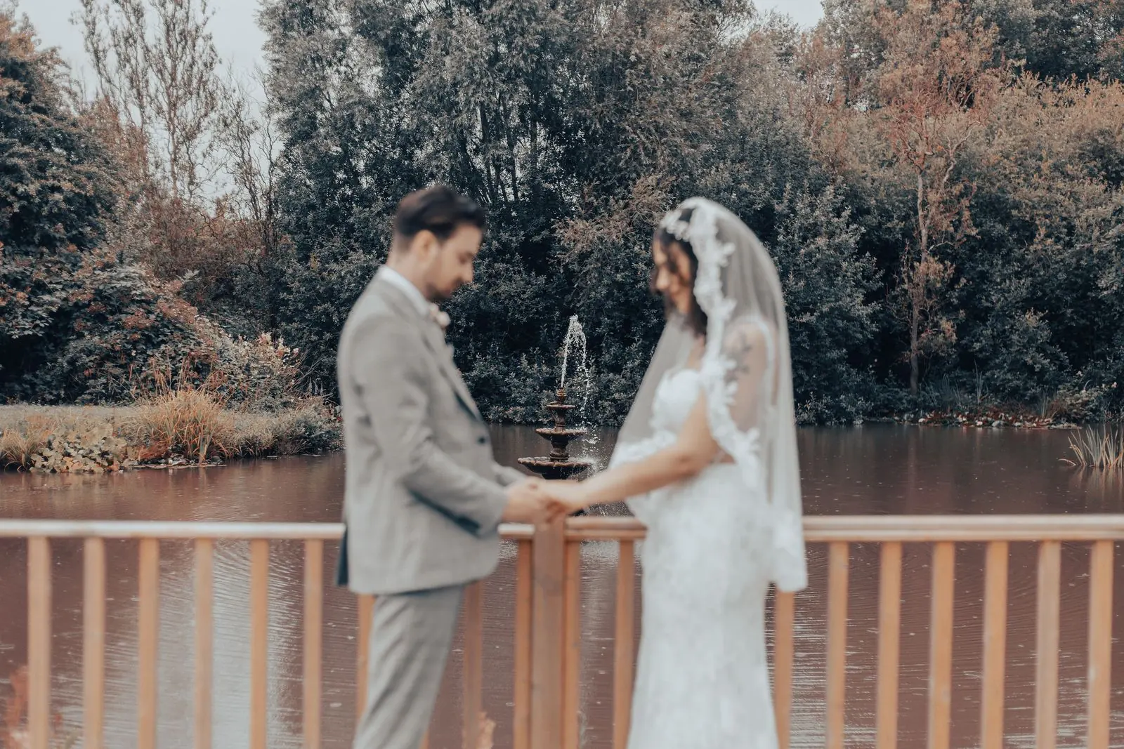 Couple facing each other on the decking by the pond