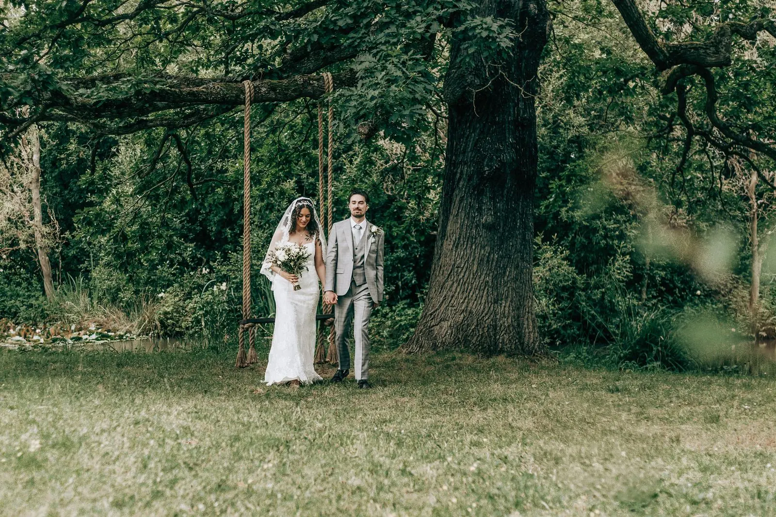 Couple walking together under a large oak tree