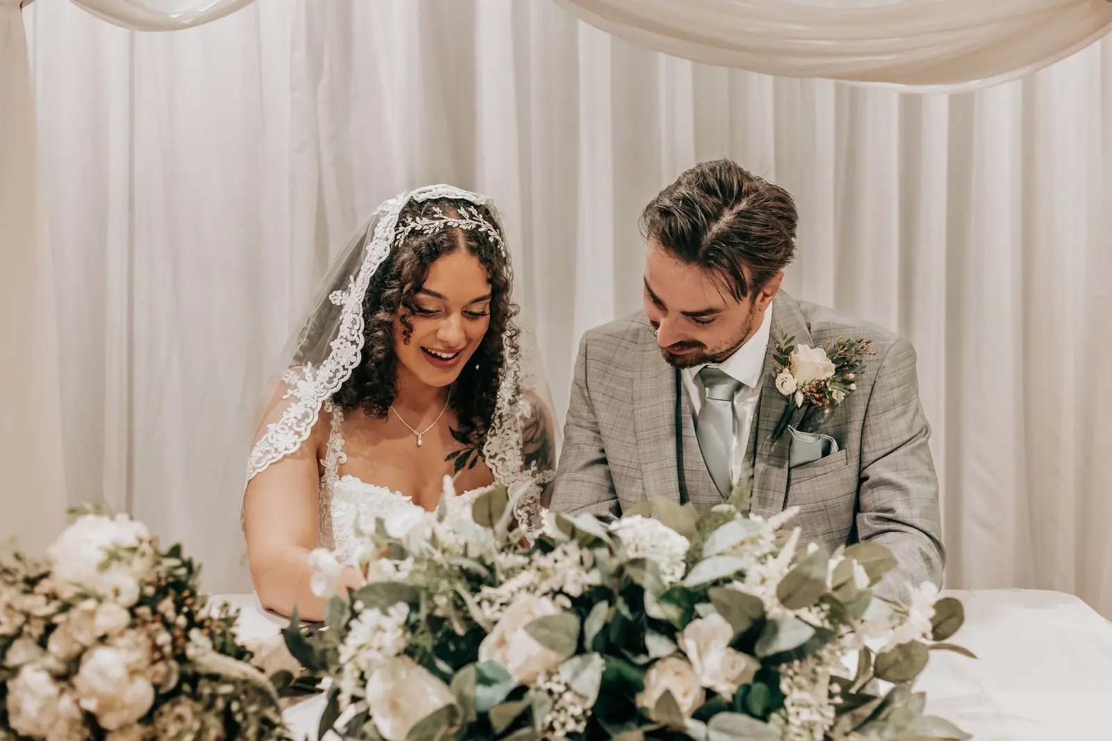 Couple signing the register surrounded by flowers