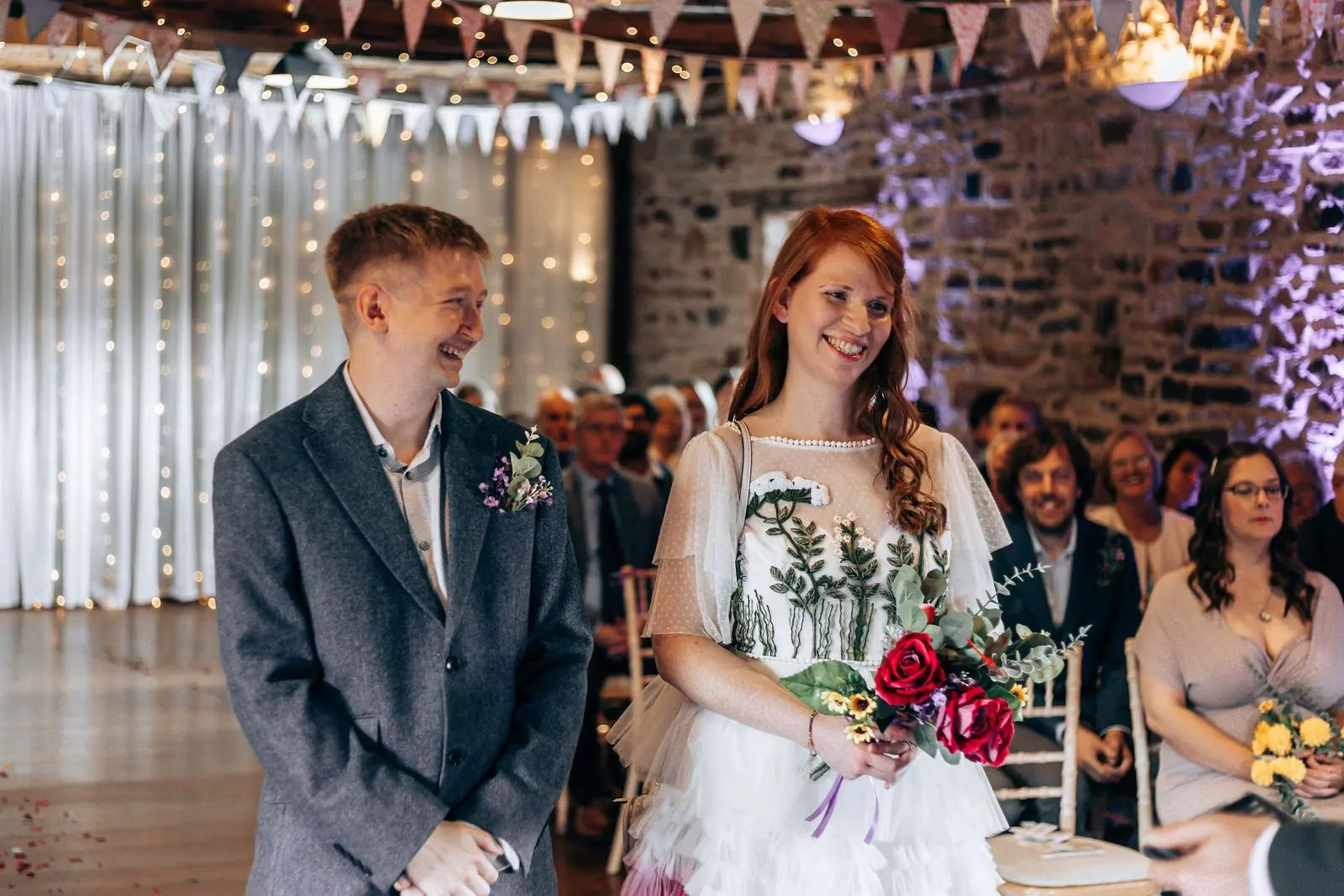 Groom smiling at his bride during the ceremony