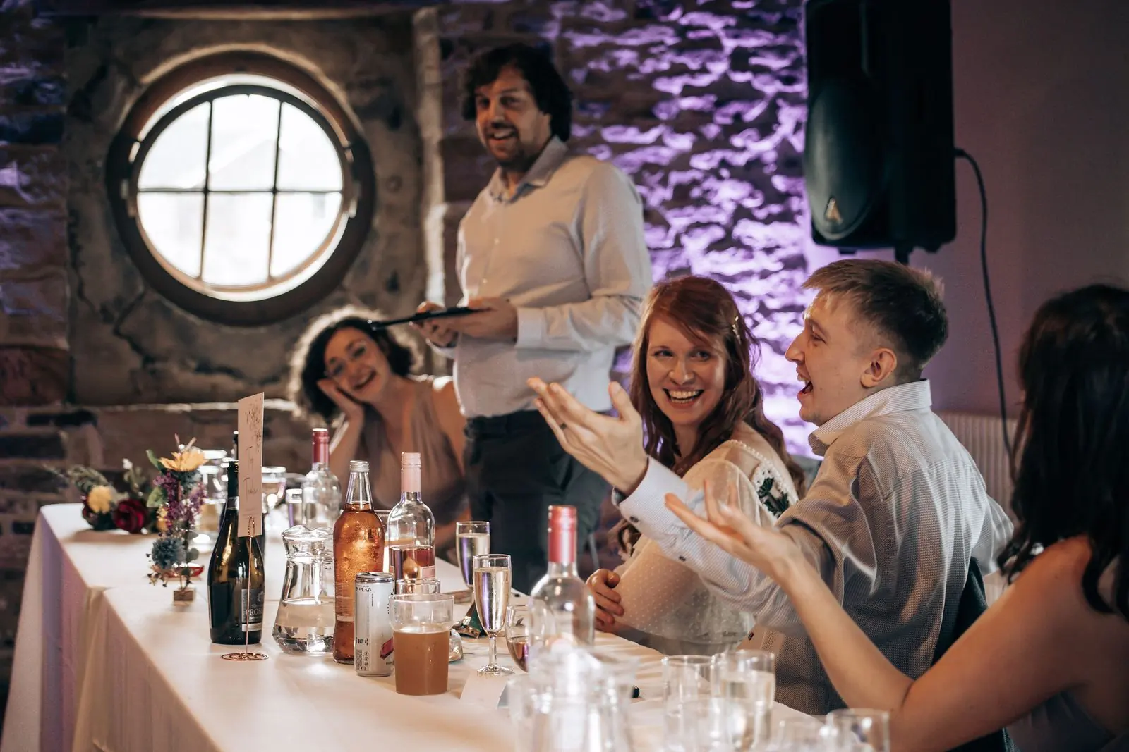 Speeches at the top table while the bride laughs